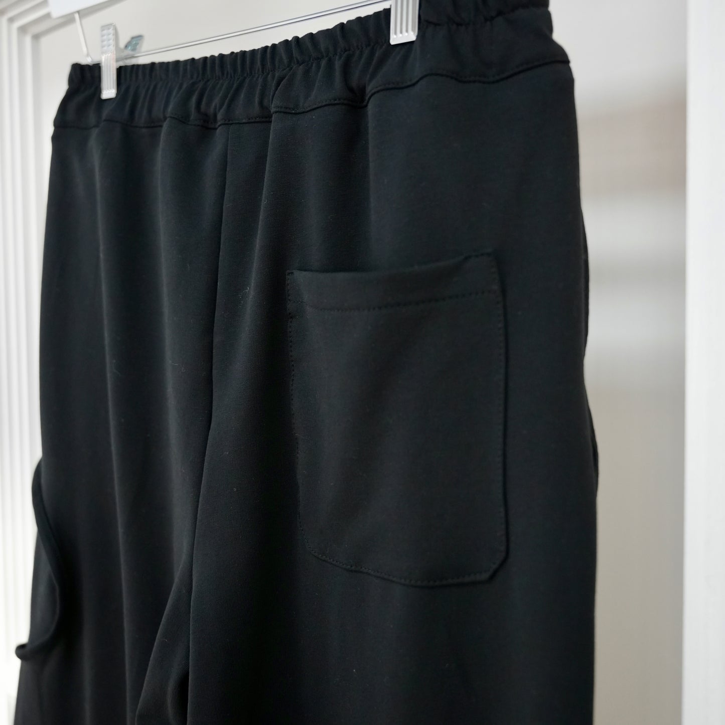 Hose Doria von Esvivid in schwarz mit lockerer Schnittführung und elastischem Bund für einen bequemen Sitz. Moderne Details wie aufgesetzte Taschen und strukturierte Einsätze verleihen ihr einen aussergewöhlnichen Look.